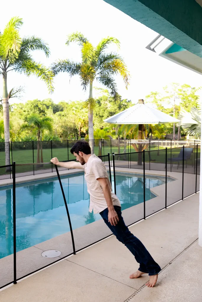 adult leans on pool fence Comead